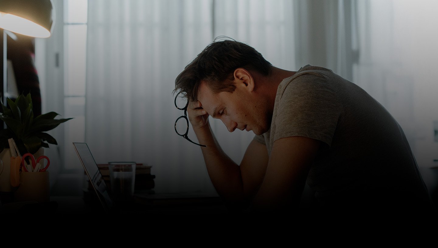 hombre con gafas en mano y computador